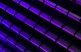 Photograph of neon purple and blue glowing bricks arranged in a 3D pattern against a dark background