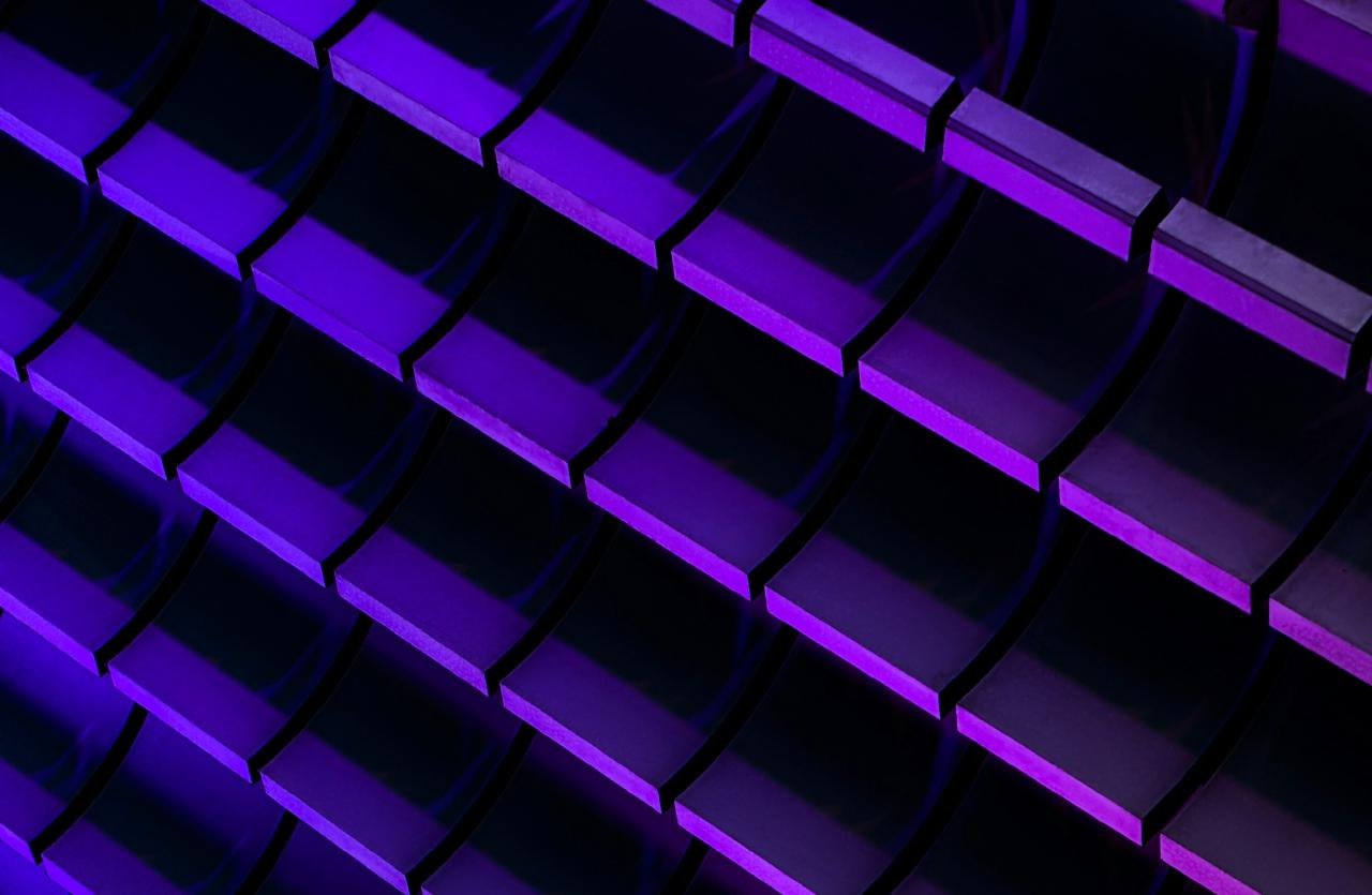 Photograph of neon purple and blue glowing bricks arranged in a 3D pattern against a dark background
