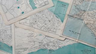 A photo of a stack of old maps. Photo taken by Annie Spratt